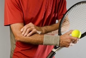 A tennis player holding elbow in pain